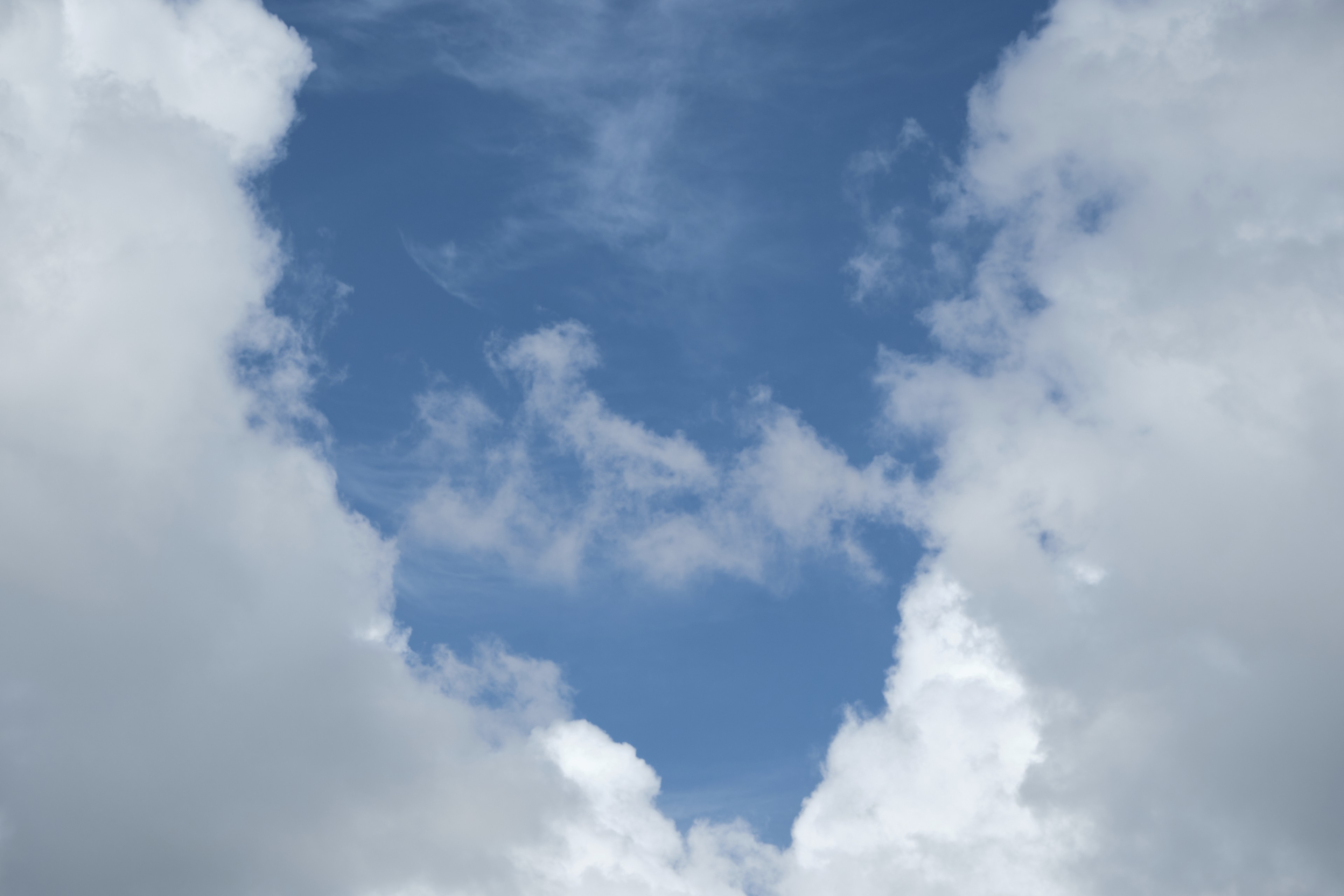 Vertical view of blue sky framed by white clouds
