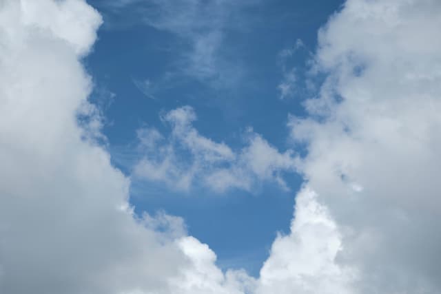 Vertical view of blue sky framed by white clouds